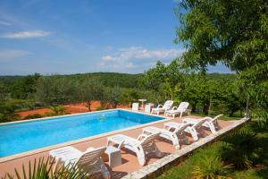 波雷奇Mugeba Club Residence的一个带白色椅子的游泳池和一个游泳池