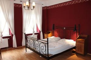 德累斯顿路易斯20号酒店的一间卧室配有一张红色墙壁和吊灯的床。