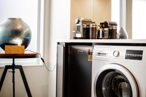朗塞斯顿Central city apartment的厨房配有洗衣机和桌子