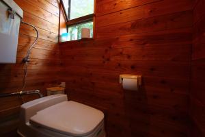 五瀨町五濑町露营地及宾馆的一间带木墙、卫生间和窗户的浴室
