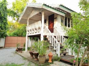 大城Baan Suan Yensabai @Ayutthaya的白色的房子,有楼梯和盆栽植物