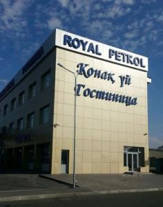 塔尔迪库尔干Royal Petrol Hotel的建筑的侧面有标志