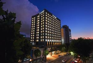 首尔Orakai Daehakro Hotel的一座高大的建筑,上面有标志