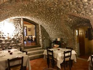 索纳安迪卡蒂莫拉德尔图尔科农家乐的一间设有两张桌子和石墙的用餐室