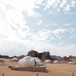 瓦迪拉姆Wadi Rum Bubble Luxotel的一片阴云天空下的沙漠中一群圆顶