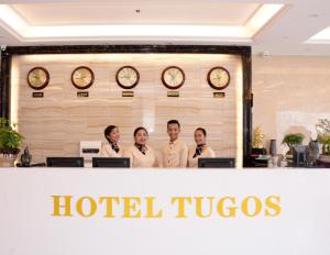 碧瑶Hotel Tugos的一群人站在酒店图哥柜台后面