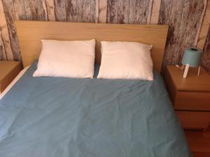 马德里Nice stay的一张带两个白色枕头和木制床头板的床