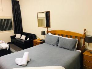 OtautauOtautau Hotel的一间卧室配有一张床、一把椅子和镜子