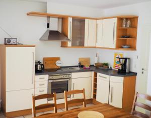 卡尔斯哈根100 Sekunden zum Strand: Schöne Wohnung auf Usedom的厨房配有白色橱柜和炉灶烤箱。