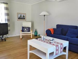 吕瑟希尔Three-Bedroom Holiday home in Lysekil 4的客厅配有蓝色的沙发和茶几