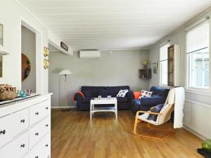 吕瑟希尔Three-Bedroom Holiday home in Lysekil 4的客厅配有蓝色的沙发和桌子