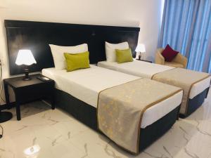 波隆纳鲁沃Agbo Hotel的酒店客房,配有两张床和椅子