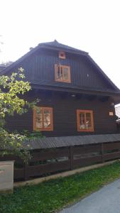大卡尔洛维采Valašské chalupy Resort的黑色房屋,设有窗户和围栏
