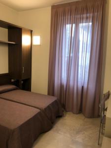 特雷佐苏拉达B&b estercarlo的一间卧室配有一张床和一个带紫色窗帘的窗户