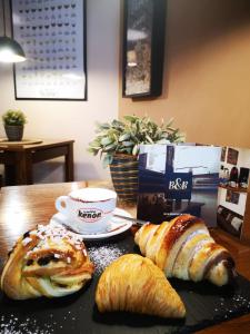 那不勒斯CASA MARINA的餐桌,包括面包和羊角面包以及一杯咖啡