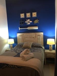 普拉亚多Praia do Forte Apartamento Fantástico的一间卧室配有一张蓝色墙壁的床和两盏灯。