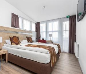 凯夫拉维克Hotel Duus by Keflavik Airport的酒店客房设有一张大床和一台电视。