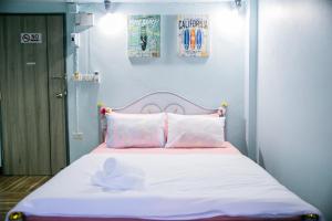 曼谷Bangkok Canale Home at Khaosarn的一张带粉色和白色床单及枕头的床
