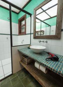 弗洛里亚诺波利斯Pousada Casa da Lagoa的浴室设有水槽和镜子,位于柜台上