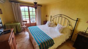 圣克鲁兹Hotel Posada Colchagua的一间卧室配有一张床、一张桌子和一个窗户。