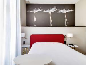 图卢兹宜必思风格图卢兹卡皮托勒酒店的卧室配有白色的床和红色床头板