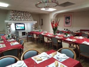卢尔德圣路易斯夏雷酒店的一间用餐室,配有红色的桌椅和壁炉