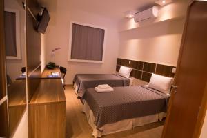 奥托兰迪亚奥托兰迪亚德亚兹酒店的小房间设有两张床和一张书桌