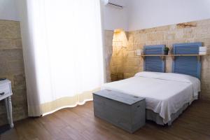 特拉尼Donato Rooms的一间卧室配有一张蓝色床头板的床