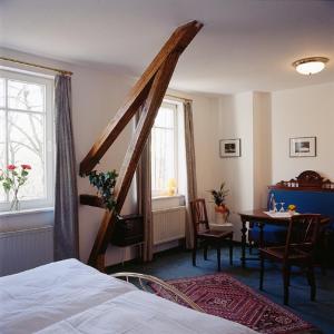 明斯特石膏磨坊乡村宾馆的一间卧室配有一张床、一张桌子和一个窗户。