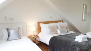 哈姆斯沃思Fresh private bedrooms with private bathroom-1 Bus to Heathrow Airport-5 minutes by car- Helpful advice from our team的一间卧室配有两张带白色床单和枕头的床。
