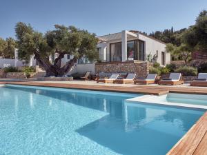 圣尼古拉奥斯PanoPlagia Villa的一个带椅子的游泳池以及一座房子