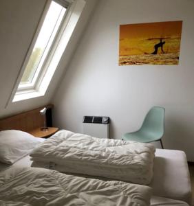 霍勒姆Appartement Waddengeluk Resort Amelander Kaap!的卧室配有床、椅子和窗户。