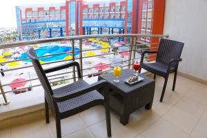开罗纳格斯托利普酒店的阳台配有一张桌子和两把椅子,享有游泳池的景色。