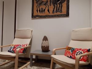 帕尔马Appartamento Soleluna的房间里的两张椅子和一个花瓶