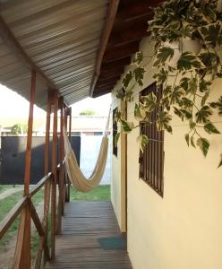 马德普拉塔卡瓦尼亚斯波多冲浪度假屋的一个带吊床的房屋门廊