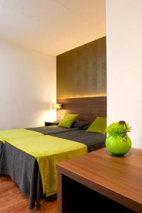 卡里拉Bed and Breakfast El Pekinaire的酒店客房设有两张床和一张桌子。
