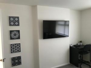 达灵顿Property Hunter 25的白色墙壁上的平面电视,配有图片