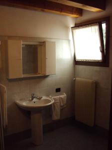 特雷维索圣安娜农庄酒店的一间带水槽和镜子的浴室以及窗户。