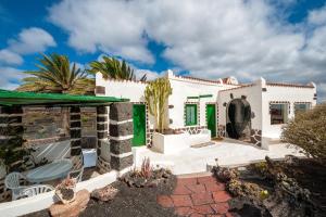 MasdacheEl Rincón的白色的房子,设有绿色百叶窗和庭院