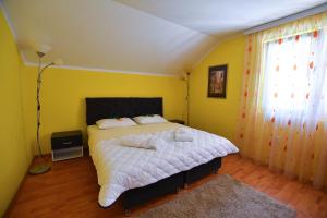 TekijaNana Tekija的一间卧室设有一张床和黄色的墙壁
