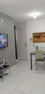马瑙斯Condomínio Conquista Premium Aleixo的客厅配有桌子,墙上配有电视