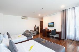 岘港Tarasa Hotel的酒店客房配有两张床和一张书桌
