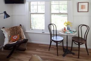 凯恩顿Bird House的客房设有桌椅和窗户。