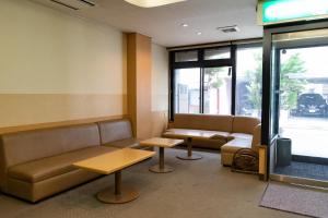 高山Tabist Kanko Business Hotel Matsuyama Hida Takayama的带沙发和桌子的等候室和窗户
