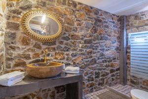 阿诺吉亚Perachori Boutique Studios的石质浴室设有水槽和镜子