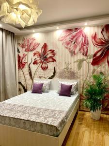 克麦罗沃Апартаменты Ленинградский, 22的一间卧室配有一张带花卉壁纸的床
