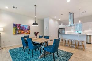 新奥尔良New Construction Elegant Villas的厨房以及带木桌和蓝色椅子的用餐室。