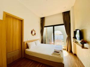 芽庄Vitamin Sea Homestay Nha Trang的一间卧室设有一张床和一个大窗户