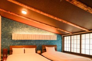 京都Yurakuan - Awagami Residence Inn的带2扇窗户的客房内的2张床
