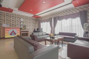 巴厘巴板RedDoorz Syariah near Taman Rozeline Penajam的带沙发和电视的大型客厅